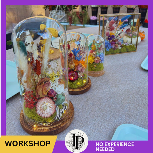 Decorative glass domes with floral arrangements on a table, workshop promotion with 'No Experience Needed' text.