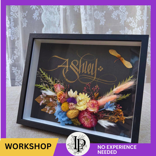 Decorative framed piece with floral and feather design, featuring the name 'Ashley'.