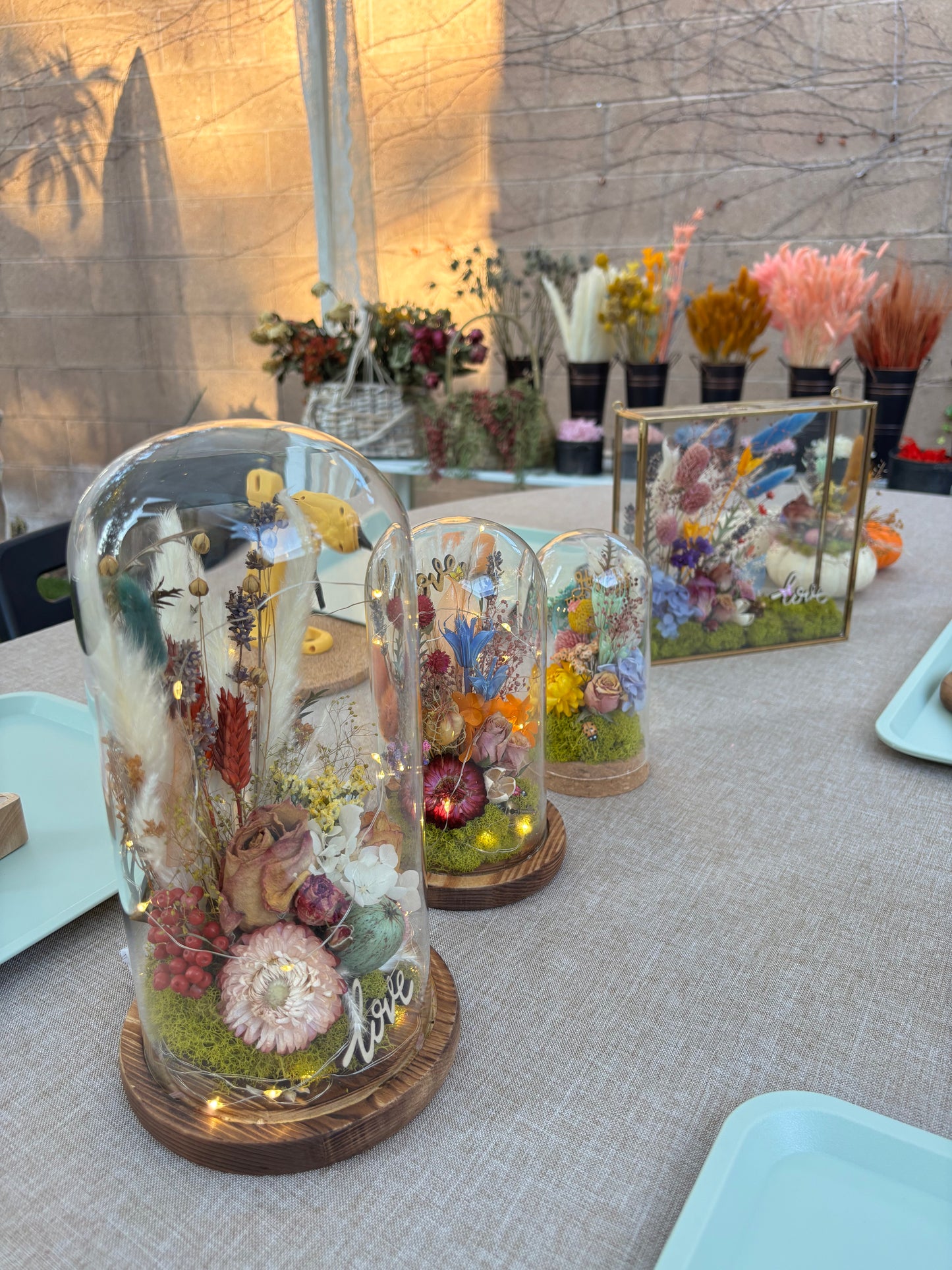 Decorative glass vases with floral arrangements on a reflective surface
