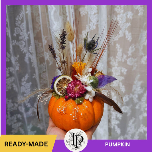 Decorative pumpkin with flowers and herbs against a floral background