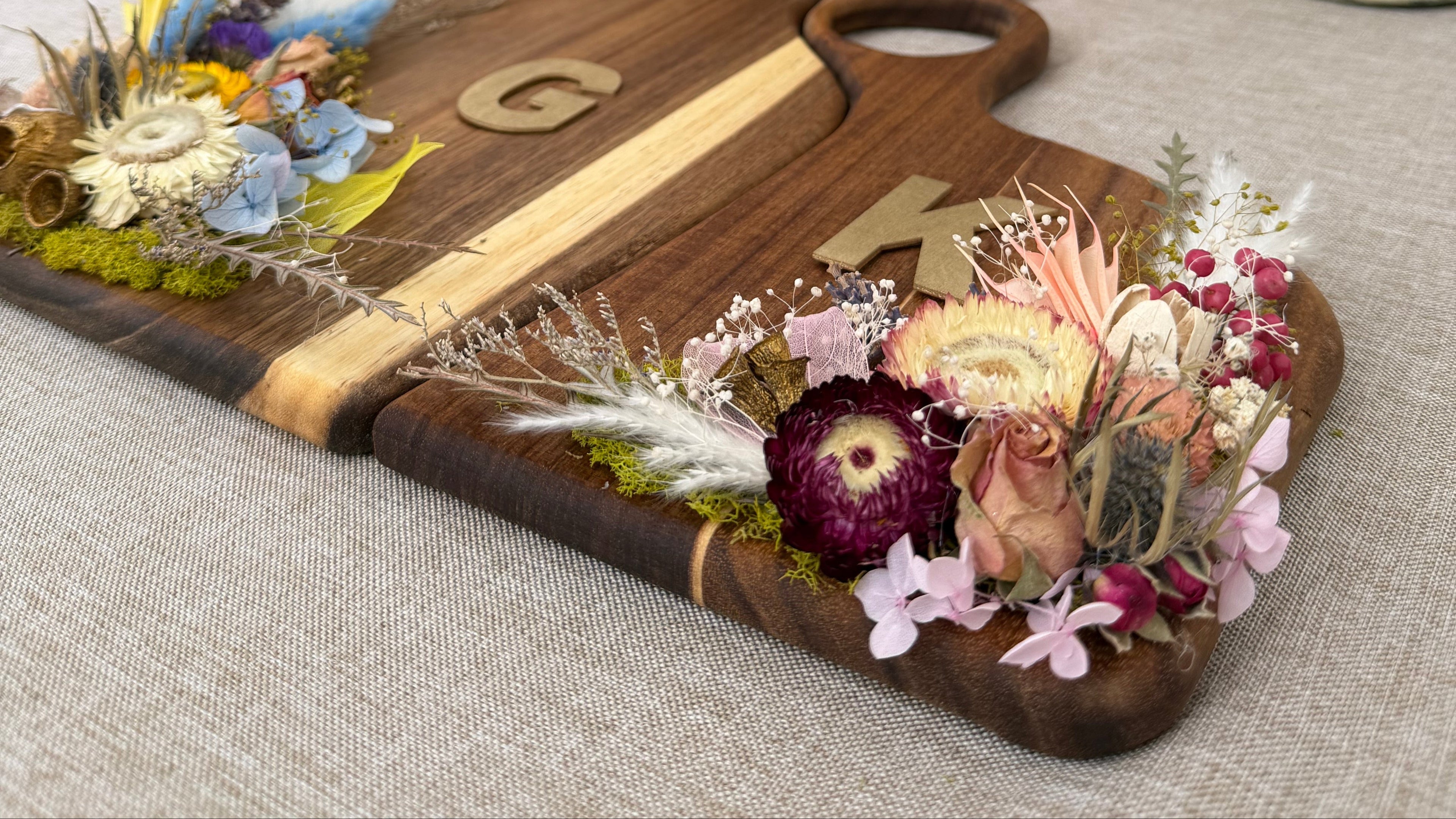 Wooden cutting board with floral decorations on a table